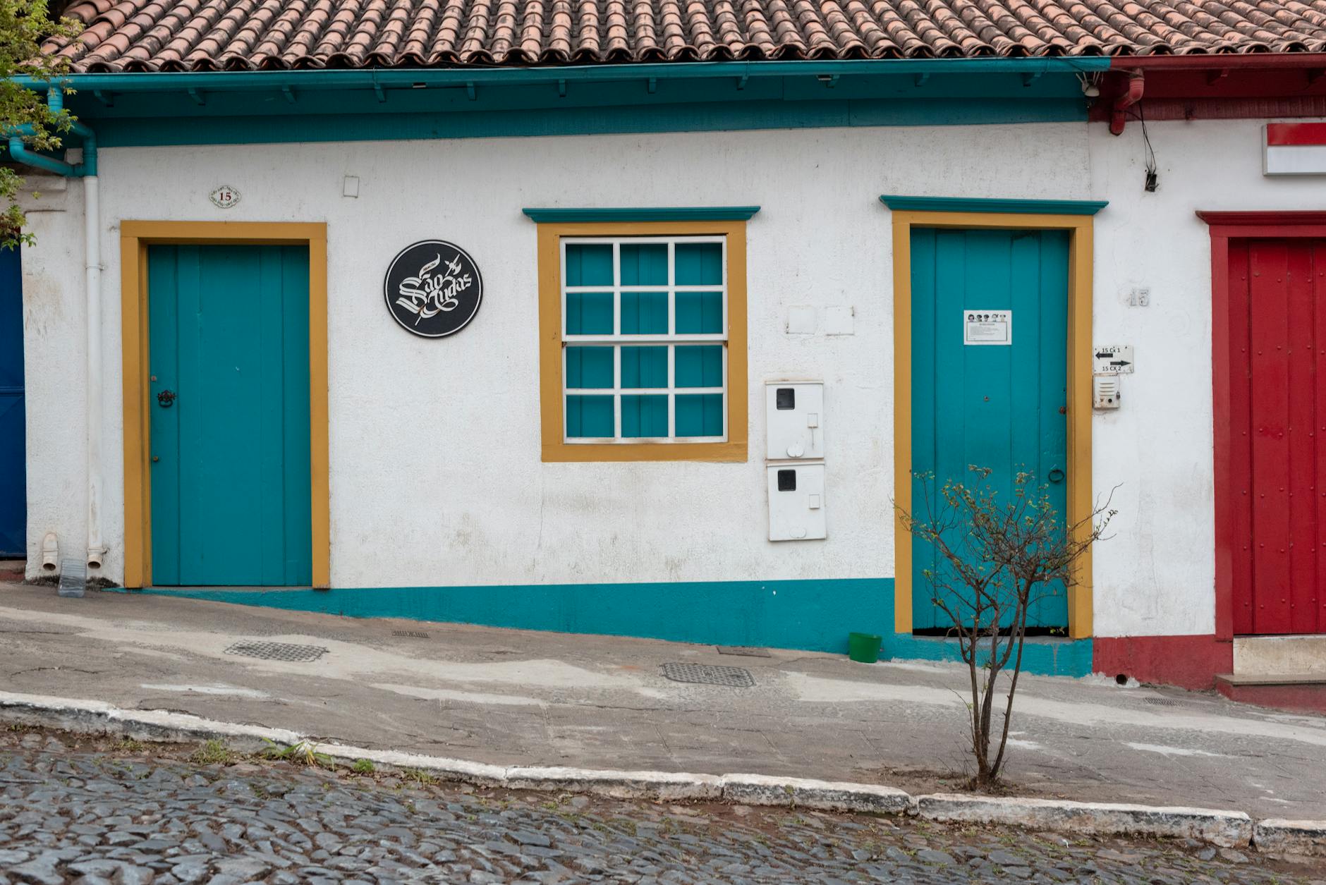 Charming colonial architecture in Sabará, Brazil, featuring vibrant teal and red doors.