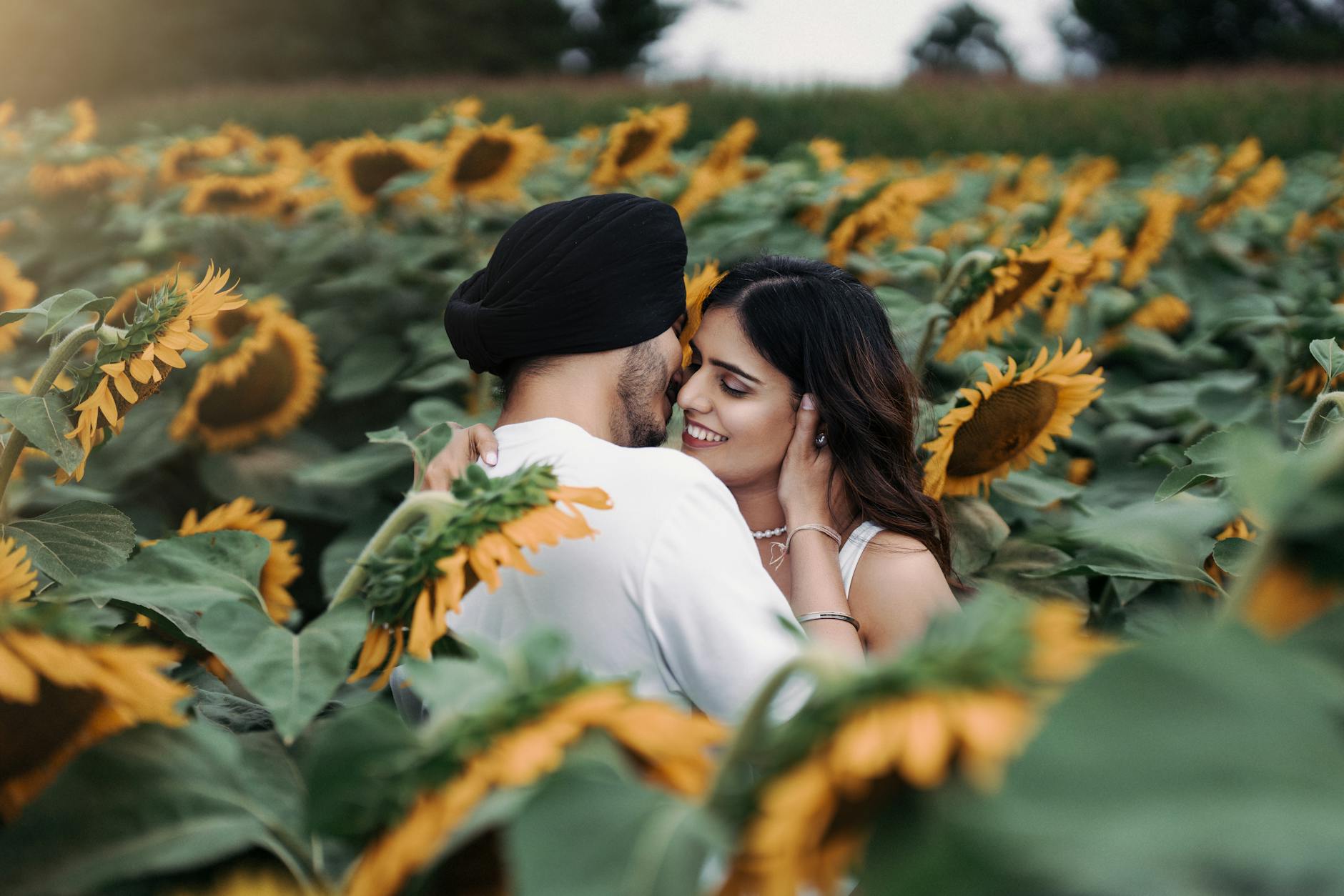 Couple embracing in a vibrant sunflower field, capturing a romantic moment in Toronto.
