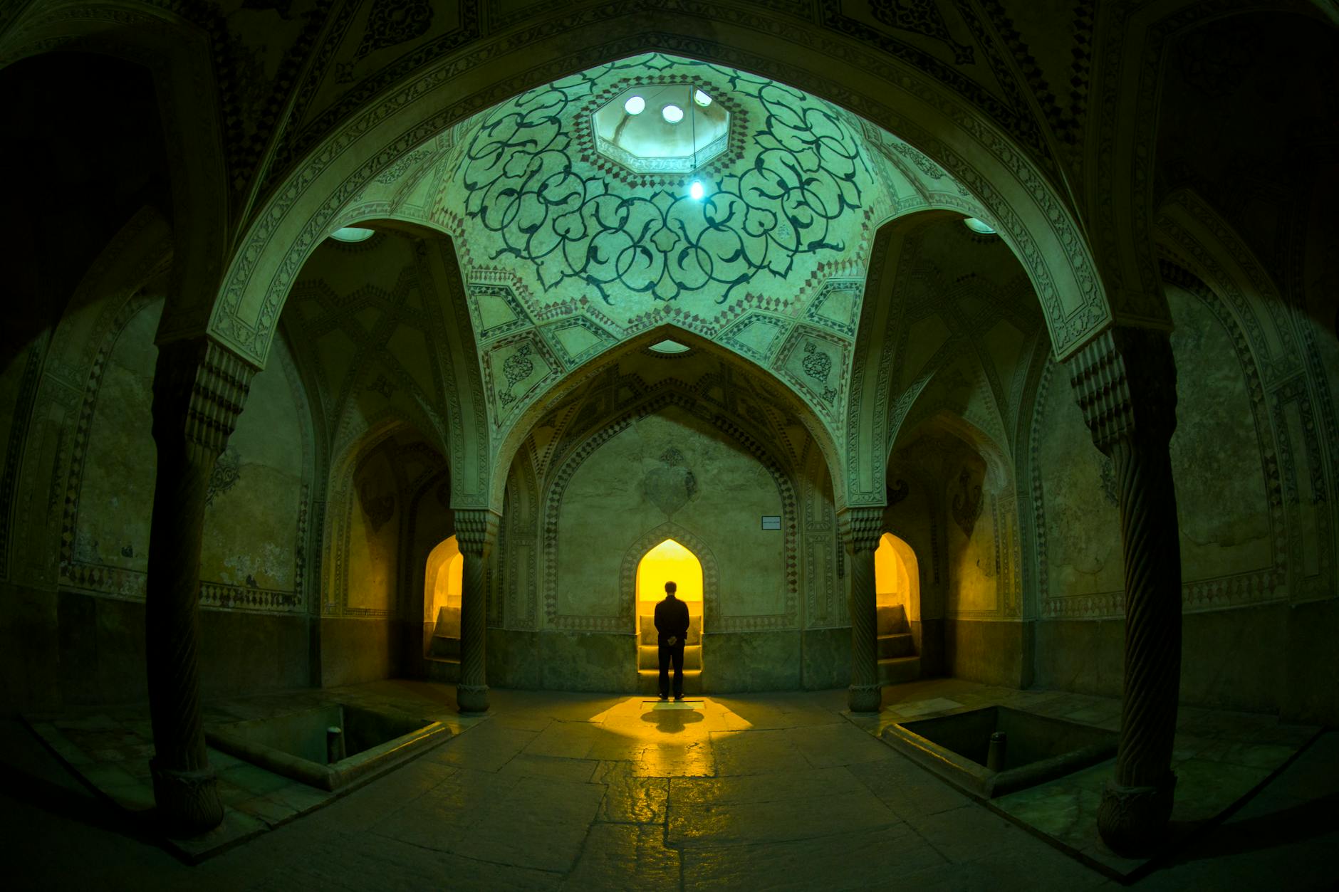 Captivating interior of a historic building in Shiraz, Iran featuring intricate design and a lone figure.