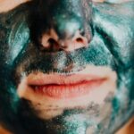 Intimate close-up of a person wearing a shimmering green facial mask promoting skincare.