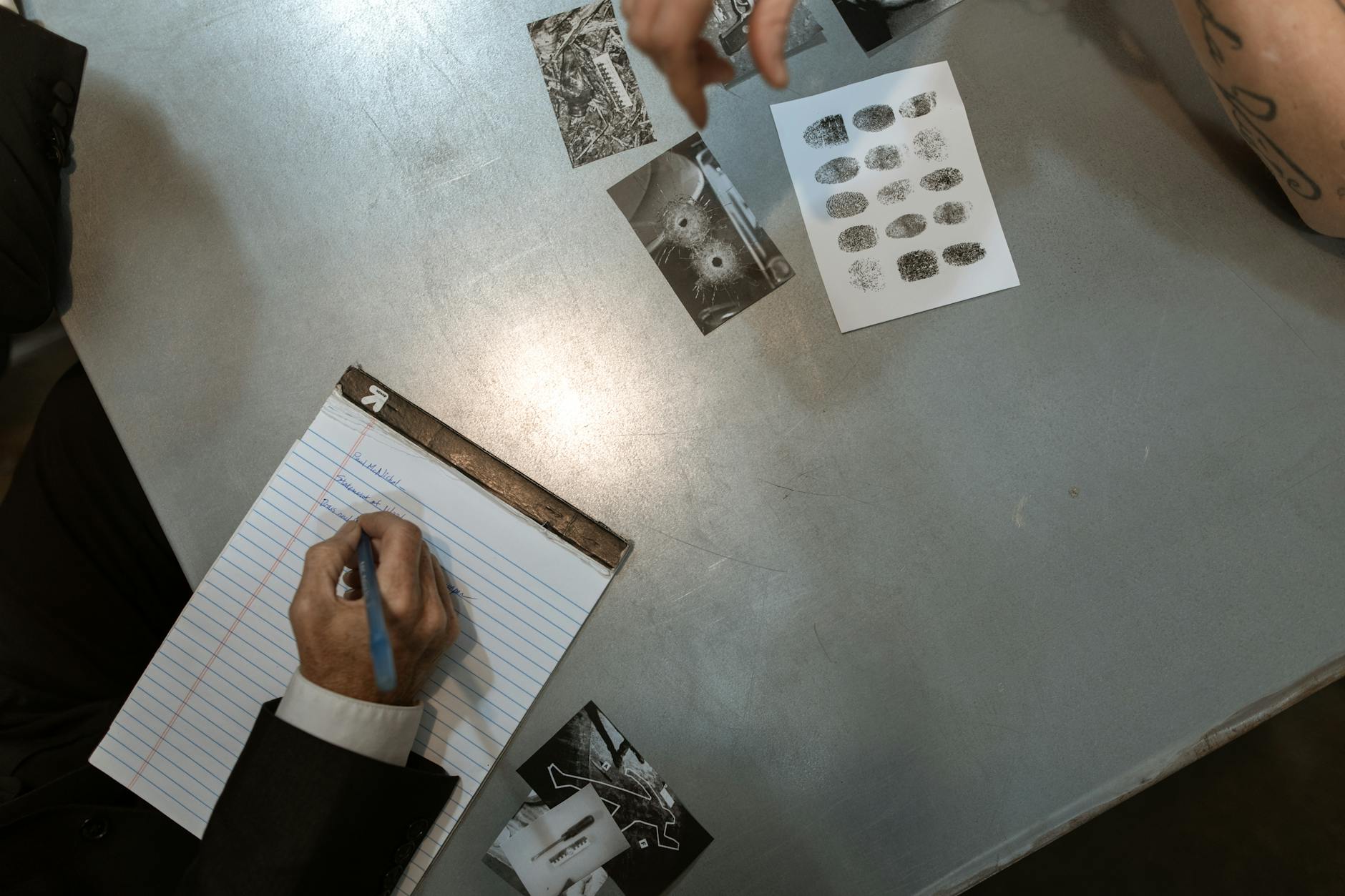 Officers at work reviewing evidence and taking notes in an investigation setting.