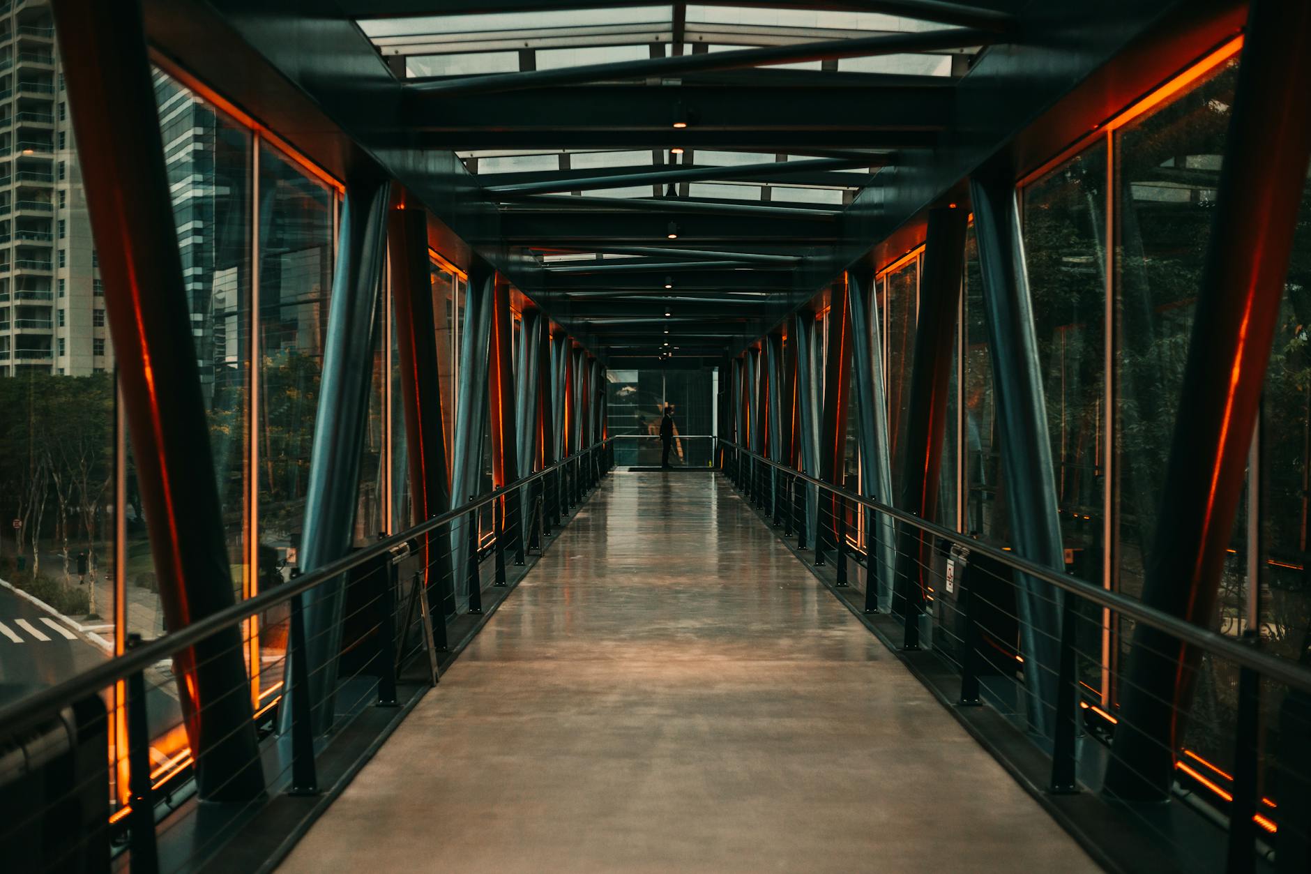 A modern glass bridge with orange illumination in São Paulo, Brazil. Perfect for travel and architecture themes.