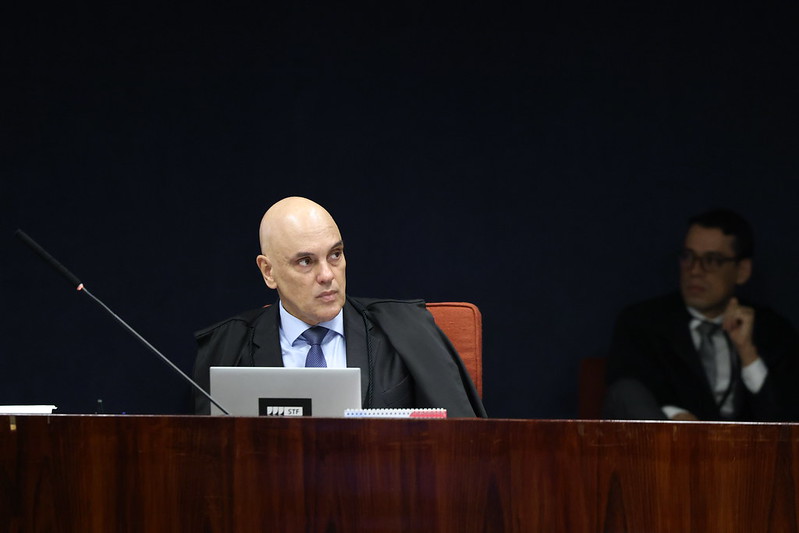 Uma balança da justiça com a Constituição Federal ao fundo, simbolizando a decisão judicial sobre a lei.