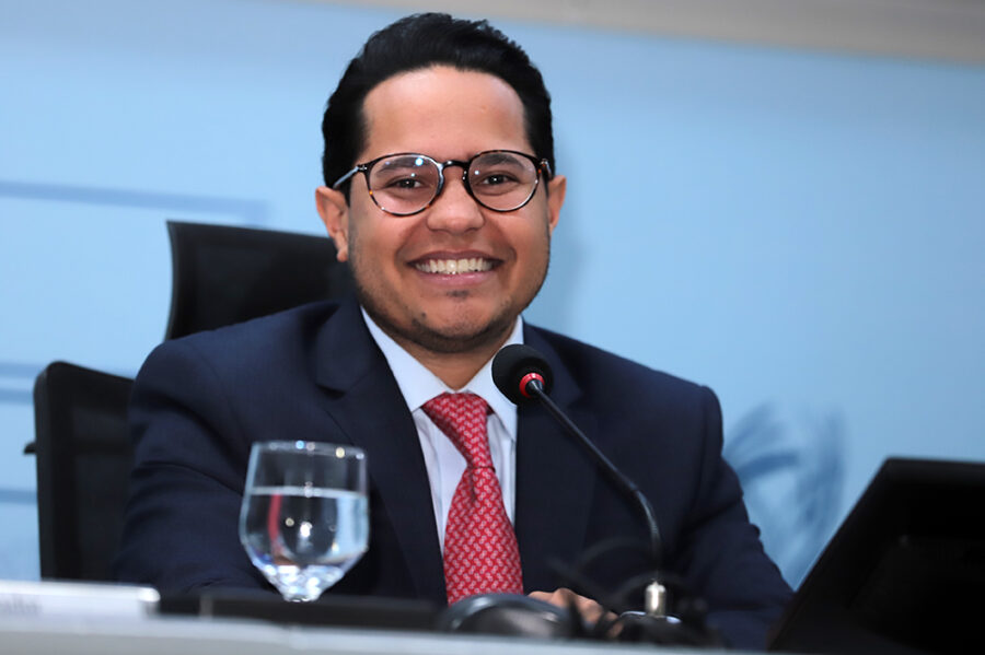 Fachada de uma mansão com elementos gráficos sobrepostos que representam dívidas e impostos, simbolizando a situação fiscal do imóvel.