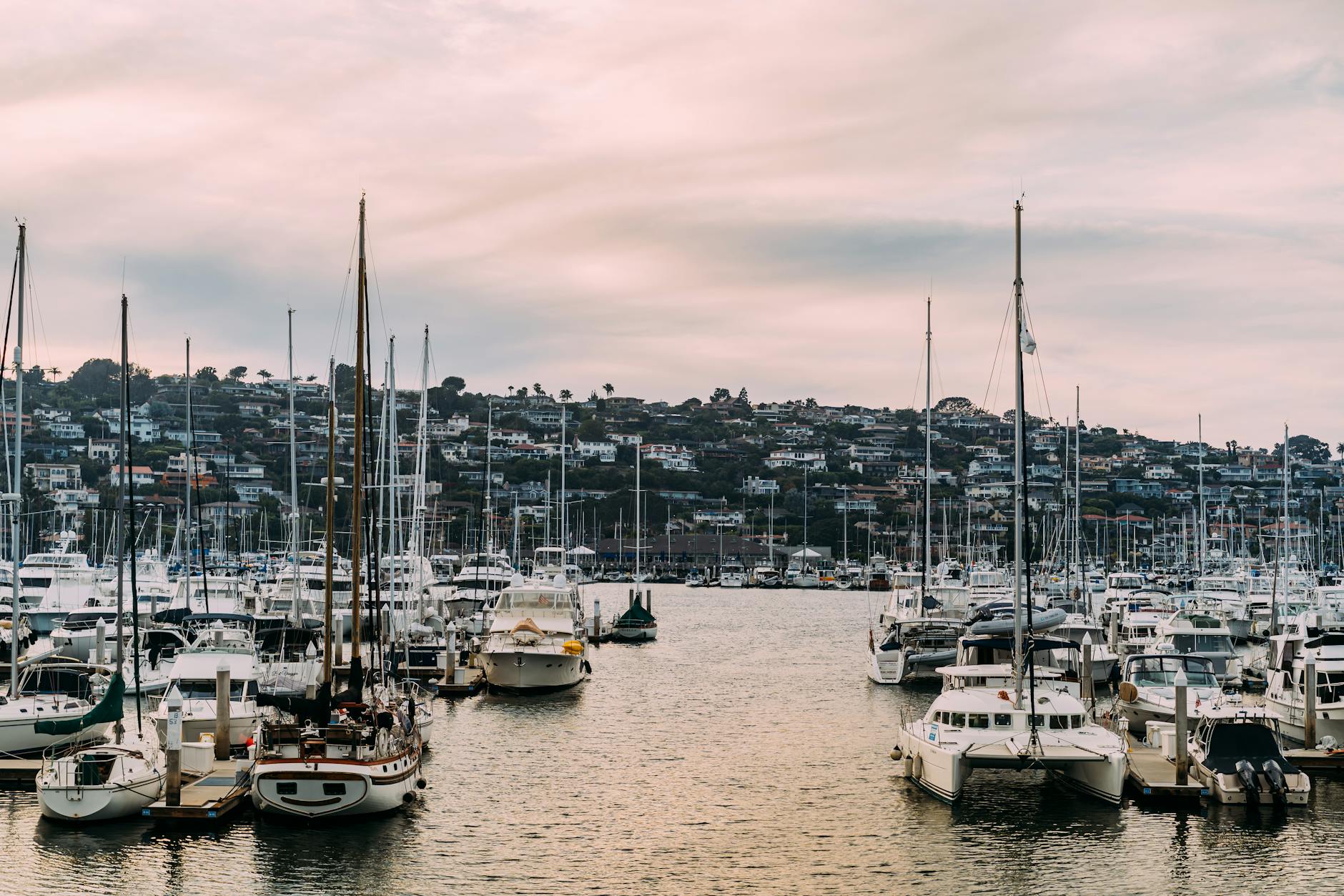 A tranquil marina scene with yachts and sailboats at sunset, ideal for travel or nautical themes.