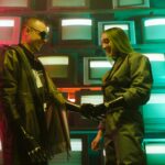 Futuristic scene of two adults shaking hands with prosthetics against a retro TV backdrop.