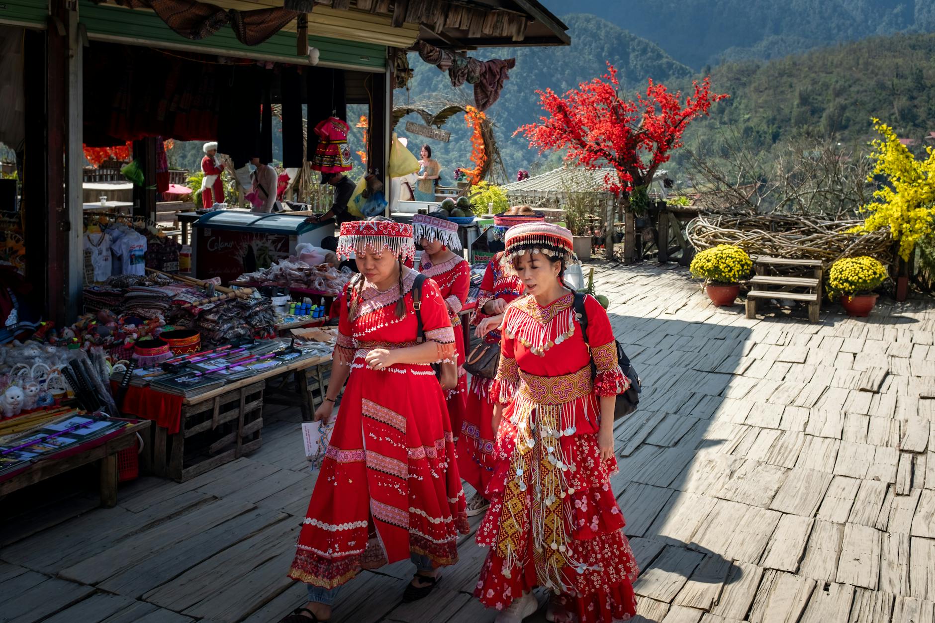Colorful traditional Vietnamese market with women in ethnic attire, vibrant surroundings.