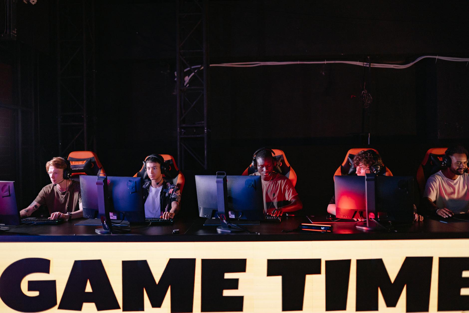 A group of diverse gamers participating in an online eSports tournament indoors.